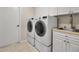 Convenient laundry room with modern washer and dryer, sink, cabinet storage at 2148 Date Palm Way, Venice, FL 34292