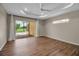 Spacious bedroom featuring wood floors, tray ceiling, and sliding glass doors at 2148 Date Palm Way, Venice, FL 34292