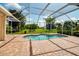 Beautiful backyard pool area surrounded by a screened enclosure with views of the green lawn at 2148 Date Palm Way, Venice, FL 34292