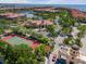 Aerial view of community with waterway, bridge, tennis court, clubhouse, and colorful terracotta roofs at 2741 Via Cipriani # 935A, Clearwater, FL 33764