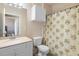 Bright bathroom with a single sink vanity, toilet, and a shower-tub combo with a patterned shower curtain at 2741 Via Cipriani # 935A, Clearwater, FL 33764
