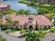 Beautiful clubhouse near waterway with terracotta tile roof is surrounded by mature landscaping and palm trees at 2741 Via Cipriani # 935A, Clearwater, FL 33764