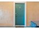 Close up of the front door to the waterfront condo featuring a teal door, exterior lighting and a welcome mat at 2741 Via Cipriani # 935A, Clearwater, FL 33764