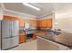 Well-equipped kitchen featuring stainless steel appliances, tile floors, and dark granite countertops at 2741 Via Cipriani # 935A, Clearwater, FL 33764