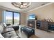 Living room featuring a fireplace, ceiling fan, leather couch, wet bar and access to the balcony at 2741 Via Cipriani # 935A, Clearwater, FL 33764