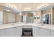 Main bathroom featuring dual sinks, white cabinets, a vanity, and plenty of mirror space at 2741 Via Cipriani # 935A, Clearwater, FL 33764