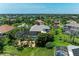 The aerial view showcases a home with a screened pool, surrounded by lush, tropical landscaping at 303 Cockle Shell Loop, Apollo Beach, FL 33572
