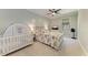 Neutral bedroom features a crib, queen bed with tropical bedding and a ceiling fan at 303 Cockle Shell Loop, Apollo Beach, FL 33572