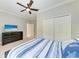 Light and airy bedroom with nautical bedding, TV, and ceiling fan at 303 Cockle Shell Loop, Apollo Beach, FL 33572