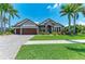 Beautiful home featuring a meticulously maintained lawn and lush tropical landscaping at 303 Cockle Shell Loop, Apollo Beach, FL 33572