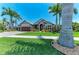 Gorgeous home surrounded by palm trees and professionally designed landscaping at 303 Cockle Shell Loop, Apollo Beach, FL 33572