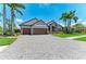 Charming home showcasing a spacious paver driveway and a manicured front lawn at 303 Cockle Shell Loop, Apollo Beach, FL 33572