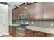 Stylish kitchen highlighting dark wood cabinets, granite countertops, and stainless steel appliances at 303 Cockle Shell Loop, Apollo Beach, FL 33572