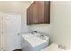 A laundry room with dark wood cabinets and a white washer and dryer at 303 Cockle Shell Loop, Apollo Beach, FL 33572