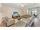 Wide angle of a spacious living room with comfortable seating and a view to an adjacent dining area at 303 Cockle Shell Loop, Apollo Beach, FL 33572