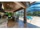 Open concept outdoor kitchen with pizza oven, bar stool seating, stainless steel grill and view of the pool at 303 Cockle Shell Loop, Apollo Beach, FL 33572