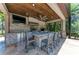 Outdoor kitchen with stone island bar seating, overhead fan, stone backsplash, stainless steel appliances and sink at 303 Cockle Shell Loop, Apollo Beach, FL 33572