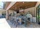 Outdoor kitchen featuring pizza oven, overhead fan, stone backsplash, stainless steel appliances, and bar stool seating at 303 Cockle Shell Loop, Apollo Beach, FL 33572