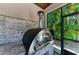 Outdoor kitchen pizza oven with stone backsplash, stainless steel door and a view to the outdoors at 303 Cockle Shell Loop, Apollo Beach, FL 33572