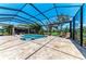 Beautiful screened pool with outdoor kitchen, bar, hot tub, sun loungers, and travertine tile at 303 Cockle Shell Loop, Apollo Beach, FL 33572