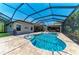 The pool area has lounge chairs, a hot tub, and an outdoor kitchen at 303 Cockle Shell Loop, Apollo Beach, FL 33572