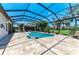 The pool area has lounge chairs, a hot tub, and an outdoor kitchen at 303 Cockle Shell Loop, Apollo Beach, FL 33572
