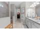 Bright bathroom featuring double sinks, granite counters, and tiled shower with bench seating at 3344 Anchor Bay Trl, Bradenton, FL 34211