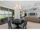 Open dining area with lake views, stylish chandelier, and access to outdoor seating, ideal for relaxation at 3344 Anchor Bay Trl, Bradenton, FL 34211