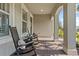 Charming front porch featuring rocking chairs and view of the professionally landscaped yard at 3344 Anchor Bay Trl, Bradenton, FL 34211