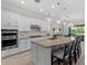 Gourmet kitchen with white cabinets, granite counters, large island, and stainless steel appliances at 3344 Anchor Bay Trl, Bradenton, FL 34211
