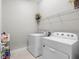 Practical laundry room with modern washer and dryer, storage, and wire shelving at 3344 Anchor Bay Trl, Bradenton, FL 34211