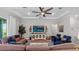 Bright living room featuring high ceilings, ceiling fan, comfortable seating, and large television at 3344 Anchor Bay Trl, Bradenton, FL 34211