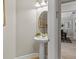 Stylish half-bathroom featuring a pedestal sink, round mirror, and neutral decor at 3344 Anchor Bay Trl, Bradenton, FL 34211