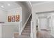 Carpeted staircase with white banisters leads to the upper level, brightened by natural light at 3344 Anchor Bay Trl, Bradenton, FL 34211