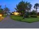 Well-manicured front yard with beautiful landscaping, mature trees, and a lighted walkway leading to the home's entrance at 355 Shore Dr, Ellenton, FL 34222