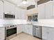 Bright kitchen with stainless steel appliances, white cabinets and a tiled backsplash at 355 Shore Dr, Ellenton, FL 34222