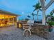Stone outdoor kitchen and gas grill under a pergola with backyard and water views at 355 Shore Dr, Ellenton, FL 34222