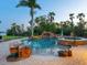 Backyard pool with rock waterfall and lush tropical landscaping at 355 Shore Dr, Ellenton, FL 34222