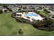 Aerial view showcases the resort style community pool, clubhouse, and beautifully landscaped green spaces at 3681 Divot Ln, Sarasota, FL 34232