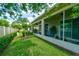 View of the screened patio, lush lawn, privacy fence, and landscaping in the backyard at 3681 Divot Ln, Sarasota, FL 34232