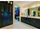 Elegant bathroom featuring dual sinks, a walk-in closet, and dark wood cabinets for ample storage at 3681 Divot Ln, Sarasota, FL 34232