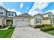 Home exterior with two-car garage, paver driveway, a manicured lawn and low maintenance landscaping at 3681 Divot Ln, Sarasota, FL 34232