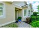 Inviting home entrance with olive front door, textured walls, manicured landscaping, and tiled walkway at 3681 Divot Ln, Sarasota, FL 34232