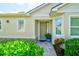 Beautiful home entrance featuring well-kept landscaping, a paved walkway and a stylish front door at 3681 Divot Ln, Sarasota, FL 34232