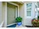 Close up of home's entry door with sidelight, potted plant, doormat, and a view of the attractive exterior at 3681 Divot Ln, Sarasota, FL 34232