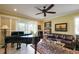 Bright living room featuring a baby grand piano, leather sofa, and large windows for natural light at 3681 Divot Ln, Sarasota, FL 34232