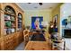 Well-appointed office featuring a wooden desk, shelving, and a peek into the nearby kitchen at 3681 Divot Ln, Sarasota, FL 34232