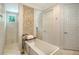 Bright bathroom featuring a soaking tub, tiled accent wall, and a separate shower with a view at 413 Partridge Cir, Sarasota, FL 34236