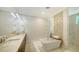 Bright bathroom featuring a tub, walk-in shower, natural stone finishes, double vanity, and stylish lighting at 413 Partridge Cir, Sarasota, FL 34236