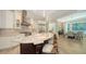 Open kitchen with long stone island and breakfast bar seating, white cabinetry, and stainless steel appliances at 413 Partridge Cir, Sarasota, FL 34236